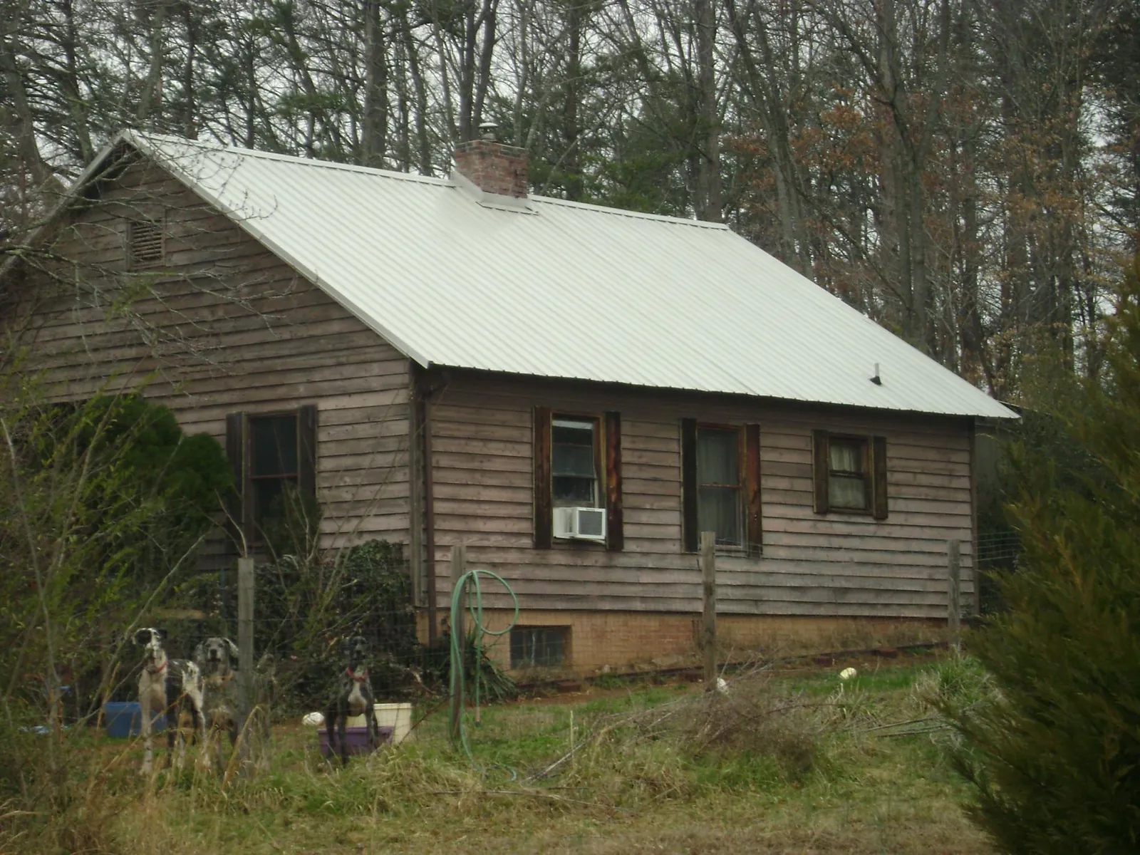 White metal roof on an old wood sided farmhouse, from a Metal Roof Installation job in Ashburn